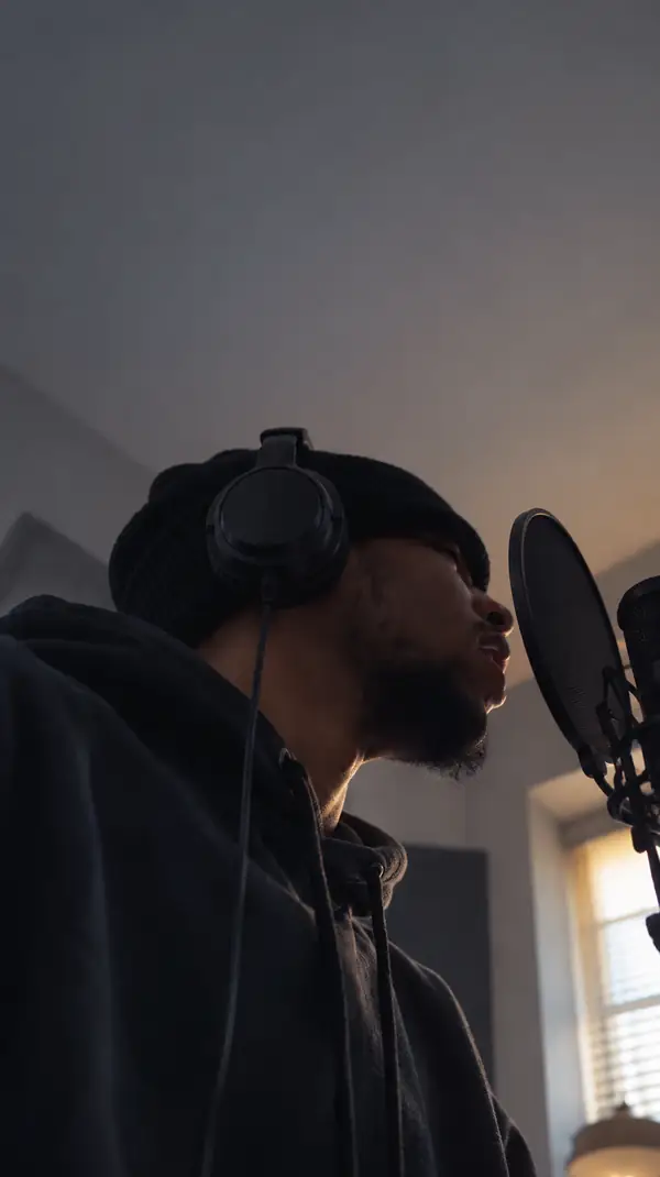 A close-up vertical video of a person recording speech indoors.
