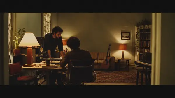 A musician discusses a recording in a portrait-oriented studio video.