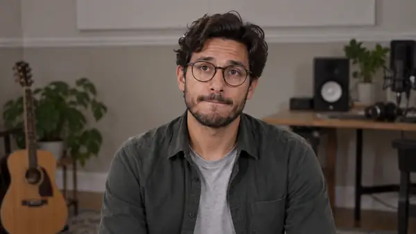 A speaker pauses mid-sentence in a vertical conversational video.